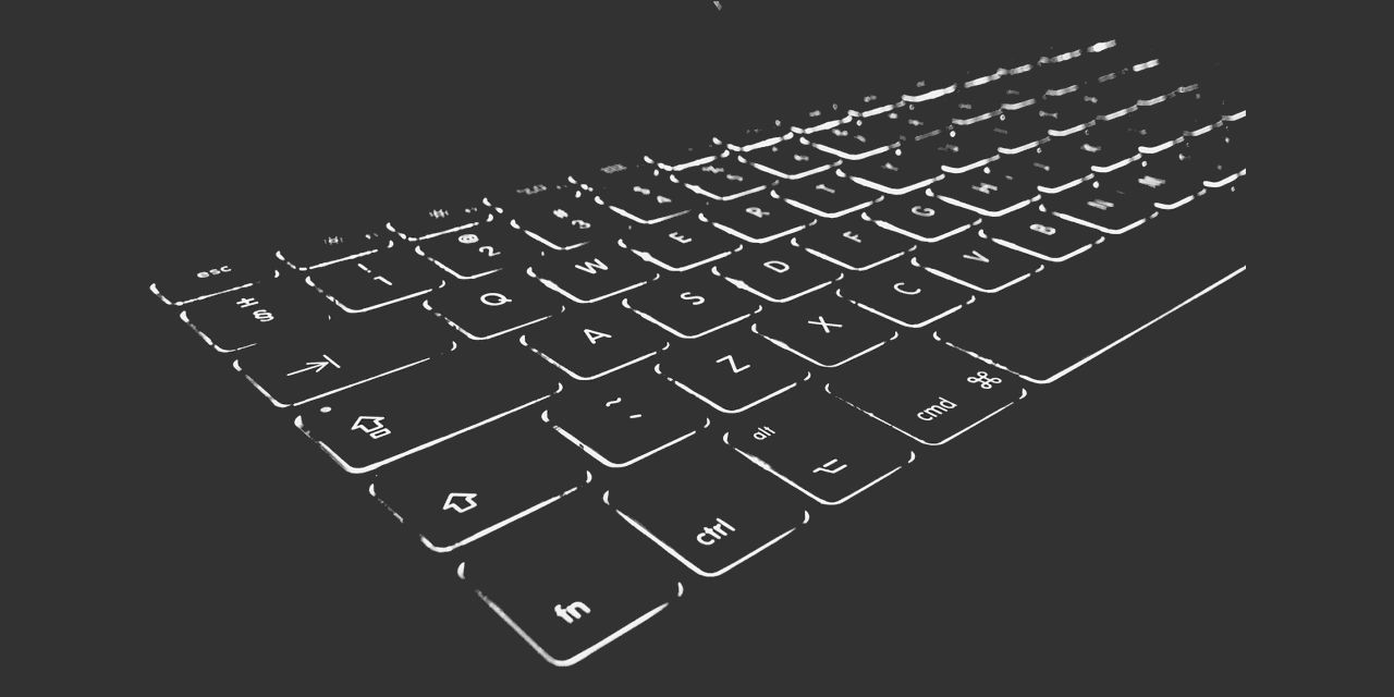 Foto representando um teclado de computador simples e que remete a outras ferramentas, à produção de conteúdo e à autoralidade e uso ético da Inteligência Artificial (IA) no contexto educacional.